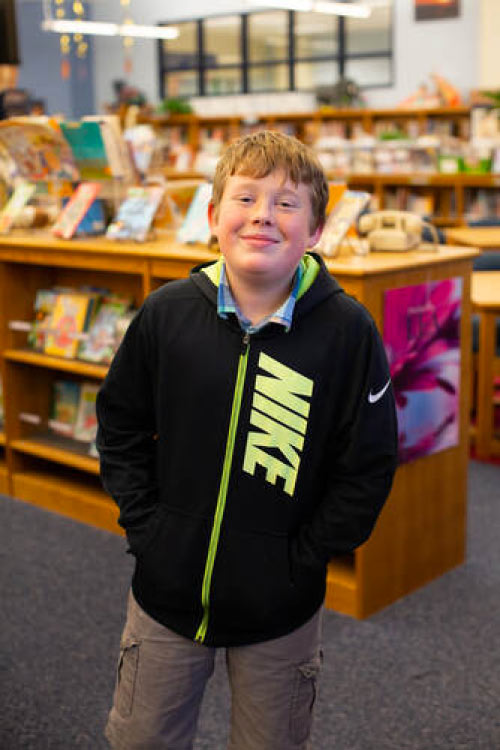 Eamon poses for a photo in his school library