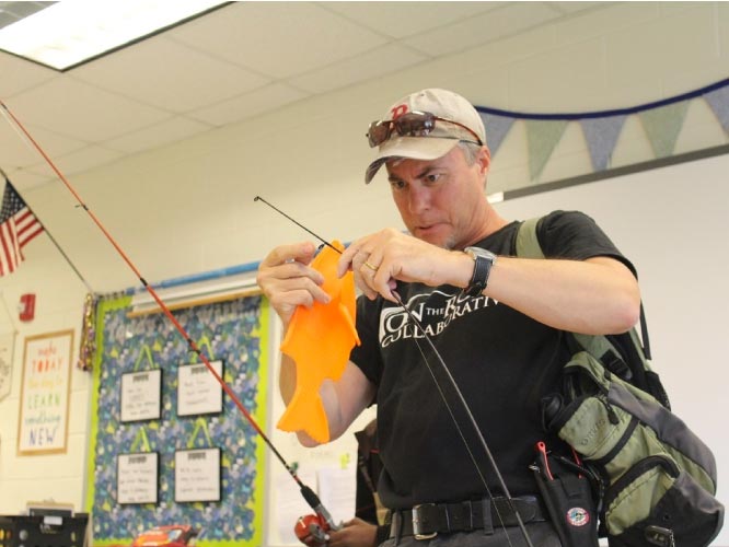 science teacher Jeff Peake teaches on the road youths about fishing