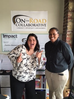 Meredith and Shaquela pose for a photo with the On the Road Collaborative sign
